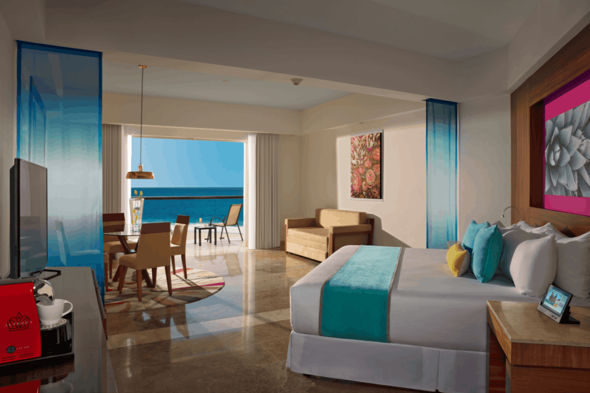 Altitude Governor Suite ocean view at Krystal Grand Los Cabos with spacious bedroom, living area, dining space and balcony facing the Sea of Cortes.